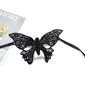 Detailed view of an elegant black lace butterfly mask on a display stand for parties