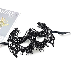 Detail of intricate black lace mask with butterfly patterns and satin ribbon ties