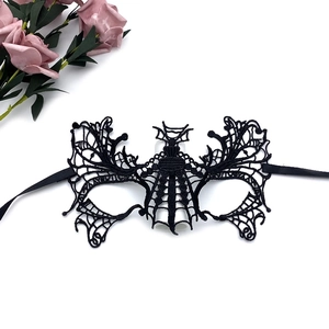 Close-up of black lace masquerade mask with intricate patterns and satin ribbons