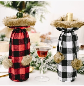 Detailed view of red and black plaid Christmas wine bottle covers with faux fur and pom-poms