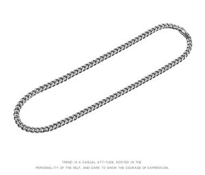 Dettaglio della collana a catena cubana in argento su uno sfondo bianco