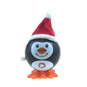 Detail shot of a wind-up Christmas penguin toy with a red star and mechanical knob