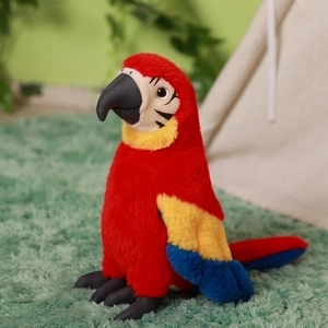 Realistic red macaw parrot plush toy with blue and yellow feather details on green rug