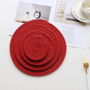 Close-up of three bright red round woven cotton rope placemats in different sizes