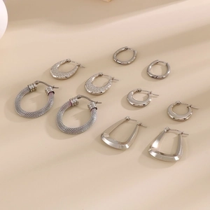 Macro view of five pairs of assorted polished silver geometric C-shape stainless steel earrings