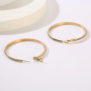 Detailed view of large gold hoop earrings with sparkling rhinestone crystals in a macro shot