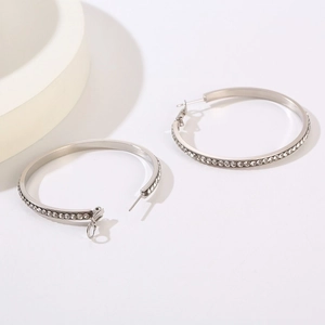 Close-up of polished stainless steel hoop earrings with sparkling crystal pavé inlay