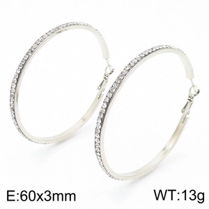 Macro detail of silver-colored 60mm hoop earrings with single row of clear rhinestones