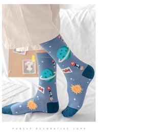 Detail of blue cotton crew socks featuring space rocket and planet patterns on fabric