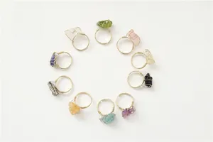 Detailed view of ten handmade gold wire wrapped rings with various raw gemstones