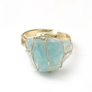 Detailed view of handmade gold wire-wrapped ring with irregular raw light blue natural stone