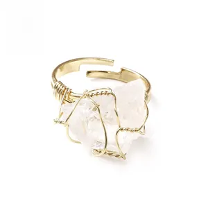 Macro view of handmade wire wrapped ring with irregular white crystal and gold metal