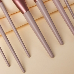 Close-up of pink makeup brush handles and metallic tubes with premium animal hair bristles