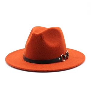 Close-up of bright orange wool fedora hat featuring a black leather band and silver rings