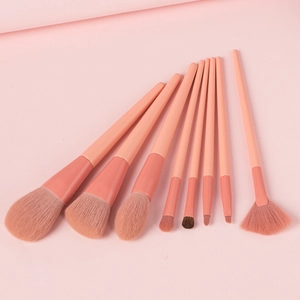 Flat lay of an 8-piece pink makeup brush set arranged in a fan shape on a matching background