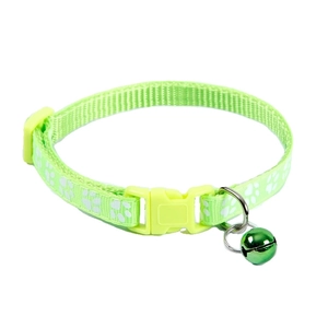 Detail of adjustable green pet collar with white paw prints and shiny green bell charm
