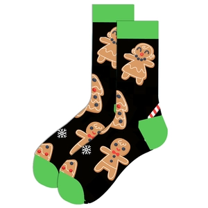Close-up of black Christmas socks with green trim featuring gingerbread man and snowflake patterns