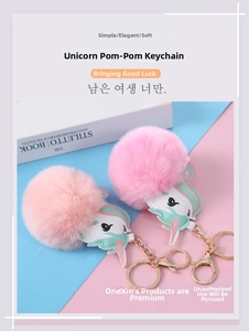 Detail of cute faux fur unicorn pompoms with gold metal clasps for bags and keys
