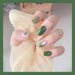 Faux ongles vert forêt avec effets marbrés et détails en feuilles d'or élégants