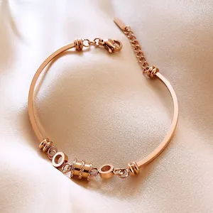 Close-up of rose gold bracelet with lobster clasp on beige silk fabric background