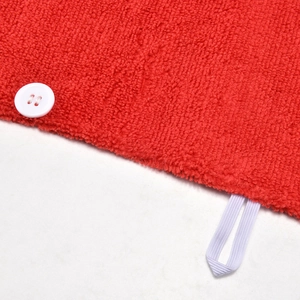Dettaglio dell'asciugamano in microfibra rossa per animali con texture e bottone bianco