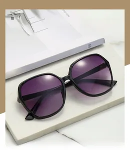 Close-up of polarized purple lenses and black square frame on a minimalist stone