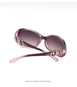 Close-up of elegant purple oversized sunglasses featuring silver metal chain temple detail