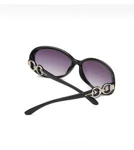 Detail of black oversized sunglasses with gradient purple lenses and silver chain temple