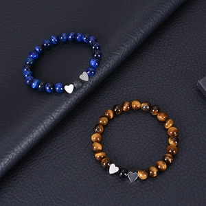 Detailed shot of tiger eye stone bead bracelets with silver heart pendants on black leather