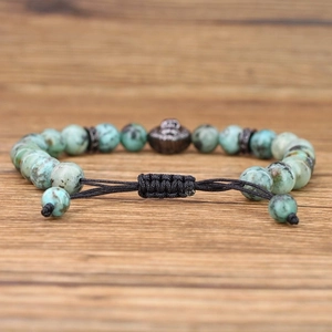 Detail of green stone bead bracelet with textured center bead and adjustable cord
