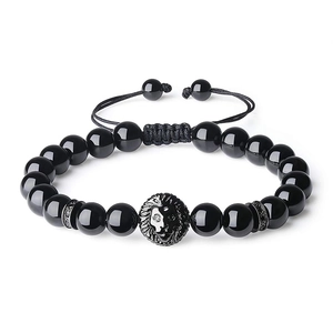 Detail of black onyx beaded bracelet with metal lion head charm and adjustable braided cord
