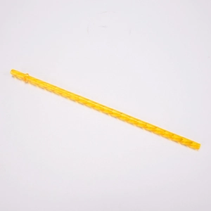Detail view of a yellow Tritan reusable straw with spiral twisted design and ring stopper