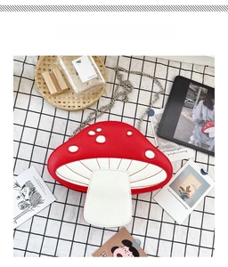 Detail of red and white mushroom-shaped PU leather crossbody bag with silver chain strap