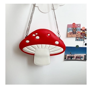 Detail of red and white mushroom-shaped crossbody bag with elegant silver chain strap