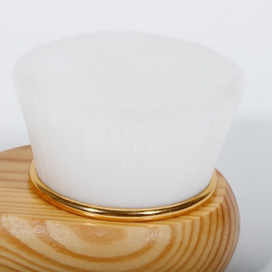 Macro shot of soft white bristles and beech wood handle with gold metal ring detail