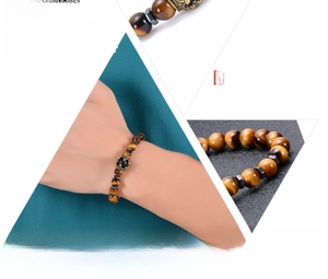 Detailed macro view of natural tiger eye stone bracelet with a golden crown charm accent