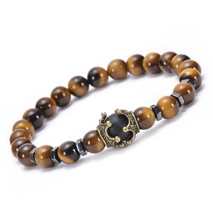 Macro view of natural tiger eye stone beads and detailed crown charm on elastic bracelet