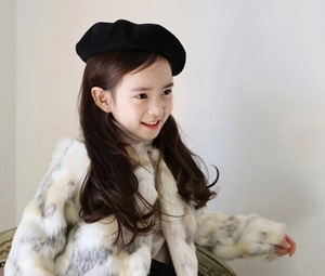 Detail of children's black wool beret and fluffy faux fur jacket for winter wear