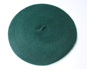 Detailed top view of dark green wool beret featuring subtle knitted texture and small stem