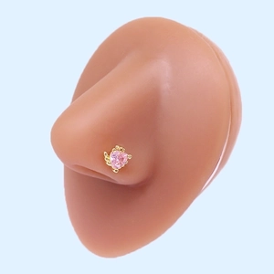 Detail of pink heart-shaped crystal nose stud with golden wings on a silicone model