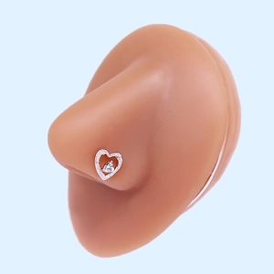 Close-up of heart-shaped silver nose stud with white zircon on professional model