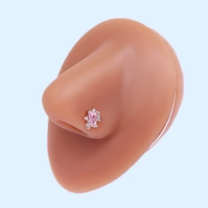 Detail view of L-shaped silver nose stud with pink rectangular zircon on a silicone model