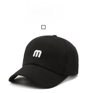 Close-up of black cotton baseball cap showing detailed white m-letter embroidery