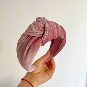Detail of pink velvet knotted headband showing vertical striped texture and retro style