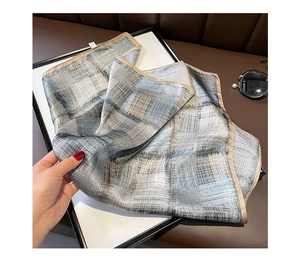 Detail showing high-quality striped silk square scarf in blue-grey with beige hem borders