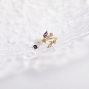 Detailed macro view of gold flower ring with colorful zirconia stones and crystal petals