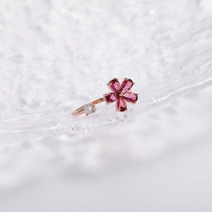 Close-up of rose gold open ring with purple floral gems and round zircon detail