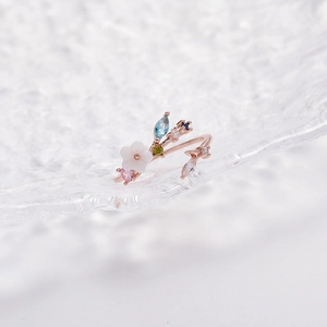 Macro detail of rose gold flower ring with colorful crystals and shell petal