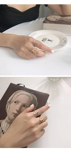 Detail von wellenförmigen minimalistischen Ringen in Gold und Silber am Finger