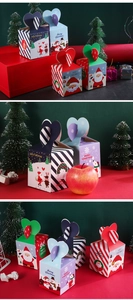 Detailed view of Christmas apple boxes with heart-shaped closures and festive illustrations
